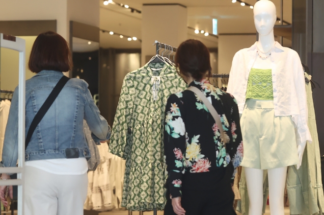 지난 19일 고객들이 서울 시내 한 의류매장 쇼윈도에 진열된 여름 패션 상품을 구경하고 있다. /사진=연합뉴스