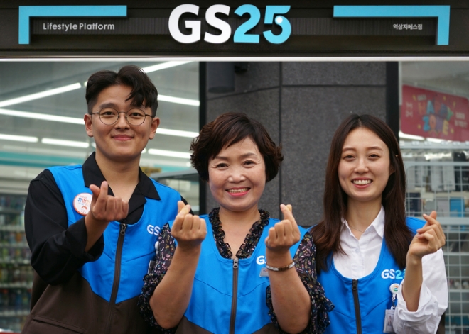 GS25 가맹 경영주와 임직원이 손하트를 만들며 포즈를 취하고 있다./사진 GS리테일