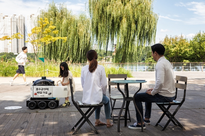 실내외 배달로봇 딜리 드라이브가 경기도 수원 광교호수공원에서 음료를 배달하고 있다./사진=우아한형제들